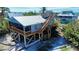 Elevated beach house with screened porch, wood decks, and stairway to rooftop terrace at 9526 Jolly Roger Trl, Placida, FL 33946