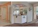 Home bar with mirrored backsplash, glass racks, and cabinet storage at 524 Pine Hollow Cir # 524, Englewood, FL 34223