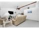 Spacious living room with beige sofas, a coffee table, and a ceiling fan at 119 Bunker Rd, Rotonda West, FL 33947