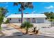 Charming single-story home with well-manicured landscaping and a white metal roof at 1493 Janet Pl, Englewood, FL 34223