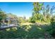 Backyard with grassy area, trees, and screened patio at 1770 Hudson St, Englewood, FL 34223