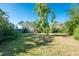 Large backyard with lush lawn and mature trees at 1770 Hudson St, Englewood, FL 34223