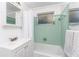 Clean bathroom with a tub, shower, white vanity, and light green tile at 1770 Hudson St, Englewood, FL 34223