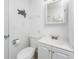 Small bathroom with white vanity, toilet, and a wall-mounted mirror at 1770 Hudson St, Englewood, FL 34223