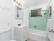 Clean bathroom with a tub, shower, white vanity, and light green tile at 1770 Hudson St, Englewood, FL 34223