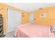 Bedroom with a double bed, peach bedding, and yellow walls at 1770 Hudson St, Englewood, FL 34223