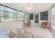 Bright sunroom with tiled floors, seating area, and access to the outdoors at 1770 Hudson St, Englewood, FL 34223