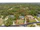 Aerial view of property line, home, landscaping and driveway leading to a paved road at 1828 Whispering Pines Cir, Englewood, FL 34223