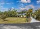 Aerial view of home, landscaping and driveway leading to a paved road at 1828 Whispering Pines Cir, Englewood, FL 34223