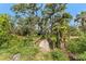 View of wooded foot bridge leading to a blue and green shed surrounded by mature trees at 1828 Whispering Pines Cir, Englewood, FL 34223