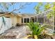 Backyard with lush foliage, a brick paver patio, and views of the home at 1828 Whispering Pines Cir, Englewood, FL 34223