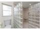 Modern bathroom featuring a glass block shower, toilet, and neutral tile flooring at 1828 Whispering Pines Cir, Englewood, FL 34223
