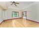 Open bedroom boasts hard wood floors, a ceiling fan, and a glass paneled door to the exterior at 1828 Whispering Pines Cir, Englewood, FL 34223