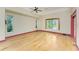 Bedroom features hard wood floors, ceiling fan, and natural light from surrounding windows at 1828 Whispering Pines Cir, Englewood, FL 34223