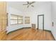 Bedroom with ceiling fan, wood floors, and plenty of natural light at 1828 Whispering Pines Cir, Englewood, FL 34223
