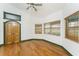 Bedroom with double door entry, wood floors, and multiple windows at 1828 Whispering Pines Cir, Englewood, FL 34223