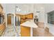 Kitchen area with bar top counter, stainless steel fridge, and view to adjacent living room at 1828 Whispering Pines Cir, Englewood, FL 34223