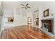 Bright living room with hardwood floors, a fireplace, and an open layout leading to the kitchen and foyer at 1828 Whispering Pines Cir, Englewood, FL 34223