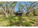 View of blue and green shed surrounded by mature trees and wild vegetation at 1828 Whispering Pines Cir, Englewood, FL 34223