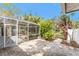 Back yard with covered porch, brick patio, and access to the house at 1828 Whispering Pines Cir, Englewood, FL 34223