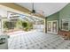 Covered and screened porch with tile floors, ceiling fans, and access to the backyard at 1828 Whispering Pines Cir, Englewood, FL 34223