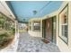 Covered front porch featuring stone flooring, a decorative wood door, and ample space for relaxing and enjoying the outdoors at 1828 Whispering Pines Cir, Englewood, FL 34223