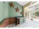 Screened-in porch features an outdoor kitchen, decorative stars, and neutral tile floors at 1828 Whispering Pines Cir, Englewood, FL 34223
