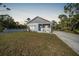 Newly built home at dusk, featuring gray siding and a white porch at 18302 Gypsy Ave, Port Charlotte, FL 33954