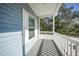 White porch railing and gray siding with a view of lush greenery at 18302 Gypsy Ave, Port Charlotte, FL 33954