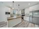 Modern kitchen with white cabinets, a large island, and stainless steel appliances at 18302 Gypsy Ave, Port Charlotte, FL 33954