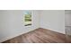 Simple bedroom with wood-look floors and a window offering natural light at 18399 Fremont Ave, Port Charlotte, FL 33954