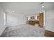 Open concept living room with gray carpet and kitchen view at 18399 Fremont Ave, Port Charlotte, FL 33954