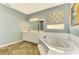 Spa-like bathroom with double vanity, a large soaking tub, and tile flooring at 186 Clear Lake Dr, Englewood, FL 34223