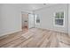 Bedroom with wood-look floors, barn door, and two windows at 19169 Mason Ave, Port Charlotte, FL 33954