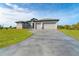 Curved driveway leading to a gray house with a three-car garage at 195 W Pine Valley Ln, Rotonda West, FL 33947