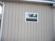 Side view of house showing tan vinyl siding and a window at 22507 Provance Ave, Port Charlotte, FL 33954