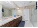 Double vanity bathroom with a large mirror and walk-in shower at 23536 Awabuki Dr # 4B, Venice, FL 34293