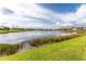 Scenic view of lake with lush landscaping and community homes at 23536 Awabuki Dr # 4B, Venice, FL 34293