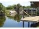 Waterfront dock offering access to a peaceful waterway with a bridge in the background at 328 Baytree Dr, Rotonda West, FL 33947