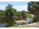 Private wooden dock on a tranquil waterway lined with lush greenery and mature palm trees at 328 Baytree Dr, Rotonda West, FL 33947