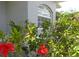 Close up of the home's exterior highlighting well-manicured landscaping and a charming arched window at 328 Baytree Dr, Rotonda West, FL 33947