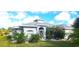 Gray one-story house with a landscaped yard, palm trees, and a screened-in entryway at 328 Baytree Dr, Rotonda West, FL 33947