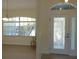 Bright foyer with stylish front door, complementing the adjacent dining area, and views of lush exterior landscape at 328 Baytree Dr, Rotonda West, FL 33947