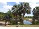 Scenic waterfront view with palm trees, a bird bath, and a charming dock on a serene canal at 328 Baytree Dr, Rotonda West, FL 33947