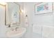 Cozy powder room features a pedestal sink with decorative artwork and complementary fixtures at 45 Seawatch Lake Dr, Boca Grande, FL 33921