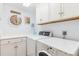 Bright laundry room featuring a modern washer and dryer, with overhead cabinets and a stylish decor at 45 Seawatch Lake Dr, Boca Grande, FL 33921