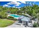 Aerial view of the community pool, surrounded by lush landscaping and a quaint pool house at 45 Seawatch Lake Dr, Boca Grande, FL 33921