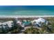 Stunning aerial view of beachfront resort, showcasing pool, lush landscaping and easy access to the sandy beach at 5000 Gasparilla Rd # 73A, Boca Grande, FL 33921