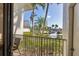 View from the balcony shows lush landscaping, palm trees, and a parking area on a sunny day at 5000 Gasparilla Rd # 73A, Boca Grande, FL 33921