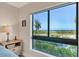 Relaxing bedroom view of the ocean and lush greenery through a large window at 5000 Gasparilla Rd # 73A, Boca Grande, FL 33921